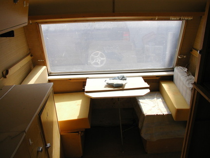 Front (hitch end) seats 2 at table, converts to single bed with single cot second bunk above.